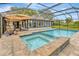 Inviting pool and spa with an umbrella inside screened in patio at 9615 Raiden Ln, Riverview, FL 33569