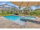 Inviting pool and spa area with brick pavers inside of screened in patio at 9615 Raiden Ln, Riverview, FL 33569
