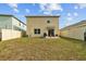 Rear exterior elevation of a home featuring a white fenced yard with a grill and patio seating at 16121 Soft Fern Trace, Odessa, FL 33556
