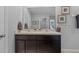 Bathroom with a double sink vanity, framed art, cream colored countertop, and mocha colored cabinets at 16121 Soft Fern Trace, Odessa, FL 33556