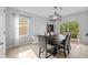 Bright dining room featuring a sleek wooden table and contemporary light fixture, perfect for Gathering meals at 16121 Soft Fern Trace, Odessa, FL 33556