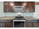 Stylish kitchen featuring stainless steel appliances, dark wood cabinets, and eat-in bar at 16121 Soft Fern Trace, Odessa, FL 33556