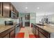 Stylish kitchen featuring stainless steel appliances, dark wood cabinets, and eat-in bar at 16121 Soft Fern Trace, Odessa, FL 33556