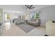 Open-concept living room featuring plush gray sofa, ceiling fan, and tile flooring at 16121 Soft Fern Trace, Odessa, FL 33556