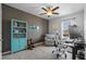 Office features ceiling fan, turquoise bookcase, accent wall, recliner, and desk with computer at 16121 Soft Fern Trace, Odessa, FL 33556