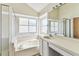 Bright bathroom showcasing a bathtub with a window and vanity sink at 10208 Evening Trail Dr, Riverview, FL 33569