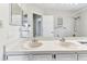 Bright bathroom featuring a double sink vanity, large mirror, and shower with white tile surround at 10208 Evening Trail Dr, Riverview, FL 33569
