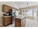 Bright kitchen boasts wood cabinets, stainless steel refrigerator, center island, and a large window at 10208 Evening Trail Dr, Riverview, FL 33569