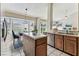 Bright kitchen features a central island, dining area, wood cabinets, and a window overlooking the yard at 10208 Evening Trail Dr, Riverview, FL 33569