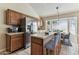 Bright kitchen features wood cabinets, stainless steel refrigerator, center island, and a dining area with large windows at 10208 Evening Trail Dr, Riverview, FL 33569