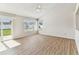 Bright living room with wood floors, a ceiling fan, and natural light from the sliding glass door and windows at 10208 Evening Trail Dr, Riverview, FL 33569