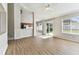Inviting living room with wood flooring, a sliding glass door, and a view into the kitchen at 10208 Evening Trail Dr, Riverview, FL 33569