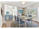 Open living room with hardwood floors, modern chandelier, connected to the dining area, and large bay windows at 10208 Evening Trail Dr, Riverview, FL 33569
