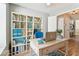 Bright office with bookshelf, a blue chair, a working desk with a laptop, and wood floor at 10208 Evening Trail Dr, Riverview, FL 33569