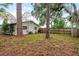 Backyard featuring a wooden fence, lawn, trees, and an air conditioning unit at 10623 103Rd St, Largo, FL 33773