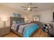 Cozy bedroom with wood floors, ceiling fan, and a large bed with colorful bedding at 10623 103Rd St, Largo, FL 33773