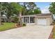 Single-story home with a screen porch, attached garage, and established yard with palm trees at 10623 103Rd St, Largo, FL 33773