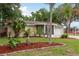 Charming home featuring a well-manicured lawn with palm trees and a screened-in porch at 10623 103Rd St, Largo, FL 33773