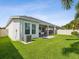 Exterior view of the house showing well-manicured lawn, screened patio, and air conditioning unit at 10669 Cardera Dr, Riverview, FL 33578