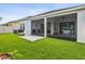 Exterior view of a home with a screened-in patio area and lush green backyard at 10669 Cardera Dr, Riverview, FL 33578