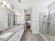 Bathroom with double vanity, granite countertops, shower with glass door, and neutral tile flooring at 10669 Cardera Dr, Riverview, FL 33578