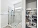 Modern bathroom with glass shower featuring elegant tile work and a built-in shelving for toiletries at 10669 Cardera Dr, Riverview, FL 33578