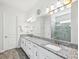Modern bathroom featuring double vanity, granite countertops and large mirror at 10669 Cardera Dr, Riverview, FL 33578