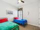 Bright bedroom with two twin beds, a ceiling fan, and light walls and carpeting at 10669 Cardera Dr, Riverview, FL 33578