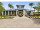 Stunning clubhouse exterior with beautiful landscaping, brick driveway, and elegant architectural details at 10669 Cardera Dr, Riverview, FL 33578