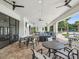Covered community patio with modern seating, ceiling fans, and a grill for outdoor entertaining by the pool at 10669 Cardera Dr, Riverview, FL 33578