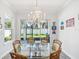 Bright dining room featuring a glass table and chandelier with a sliding door to the backyard at 10669 Cardera Dr, Riverview, FL 33578