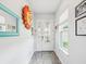 Bright entryway with gray flooring, decorative mirror and sun art piece, and a view of the front door at 10669 Cardera Dr, Riverview, FL 33578