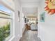 Bright hallway leading into the living area features wood-look tile, windows, and decorative wall art at 10669 Cardera Dr, Riverview, FL 33578