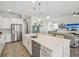 Bright, open-concept kitchen with stainless appliances and large center island open to living area at 10669 Cardera Dr, Riverview, FL 33578
