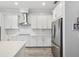 Modern kitchen features white cabinets, stainless steel appliances, and tile backsplash at 10669 Cardera Dr, Riverview, FL 33578
