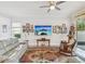 Spacious living room with entertainment center, surf board decoration, and views to the outside at 10669 Cardera Dr, Riverview, FL 33578