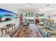 Open-concept living room features a large TV, eclectic decor, and sliding glass doors to the patio at 10669 Cardera Dr, Riverview, FL 33578