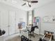 Bright home office includes a modern desk, shelving unit, and workout equipment set against neutral walls at 10669 Cardera Dr, Riverview, FL 33578
