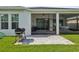 Screened patio with tiled flooring features a grill, ceiling fans, and views of the lush backyard at 10669 Cardera Dr, Riverview, FL 33578