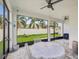 Inviting screened patio featuring a ceiling fan and a table for outdoor dining with a view of the backyard at 10669 Cardera Dr, Riverview, FL 33578
