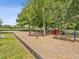 Community playground area with playhouse, equipment, mulch ground cover, and surrounding green trees at 10669 Cardera Dr, Riverview, FL 33578