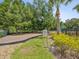 Community playground sign and equipment with mature trees and green space surrounded by black fence at 10669 Cardera Dr, Riverview, FL 33578