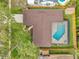 Aerial view of the home's roof, screened pool, fenced yard, patio, landscaping, and driveway at 11245 Bella Loma Dr, Largo, FL 33774