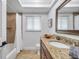 Bright bathroom featuring granite counters, decorative accents, and a shower/tub combo with a white shower curtain at 11245 Bella Loma Dr, Largo, FL 33774