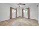 An empty bedroom featuring an updated ceiling fan, tile floors, and dual windows with curtains at 11245 Bella Loma Dr, Largo, FL 33774