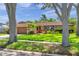 Charming home framed by trees boasts a lush lawn, mature landscaping, and attached garage at 11245 Bella Loma Dr, Largo, FL 33774