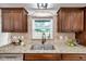 A kitchen sink under a window features granite counters and stainless steel appliances at 11245 Bella Loma Dr, Largo, FL 33774
