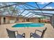 Backyard view of a screened-in pool with lounge chairs on the brick deck and blue skies overhead at 11245 Bella Loma Dr, Largo, FL 33774