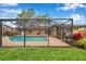 Backyard view of screened pool with brick patio and green grass at 11245 Bella Loma Dr, Largo, FL 33774