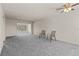 Bright living room featuring neutral paint, carpet, and large window letting in natural light at 11620 Park Blvd # 306, Seminole, FL 33772